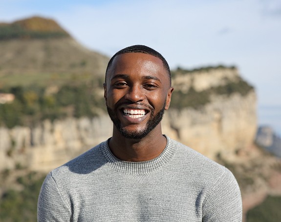 a man standing outdoors and smiling