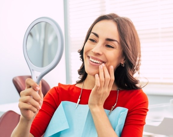 Woman looking at smile after makeover