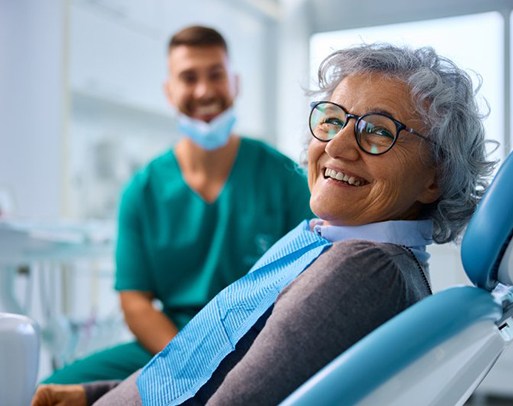 a patient smiling while wearing her new dentures