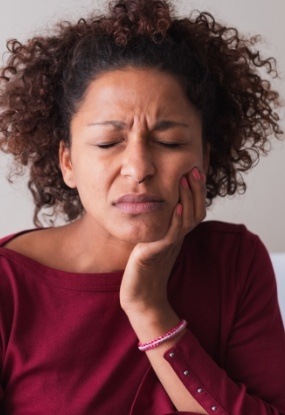 Woman in need of emergency dentistry holding jaw in pain