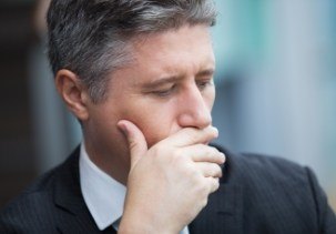 Man with lost filling covering his mouth