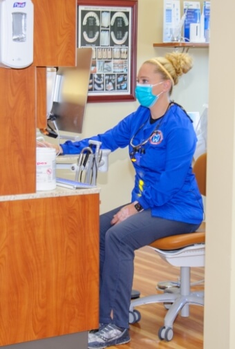 Dental team member looking at chairside computer