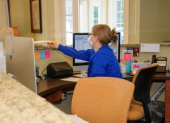 Dental team member giving patients forms