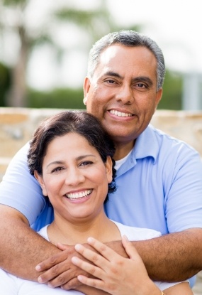 Man and woman smiling after restorative dentistry