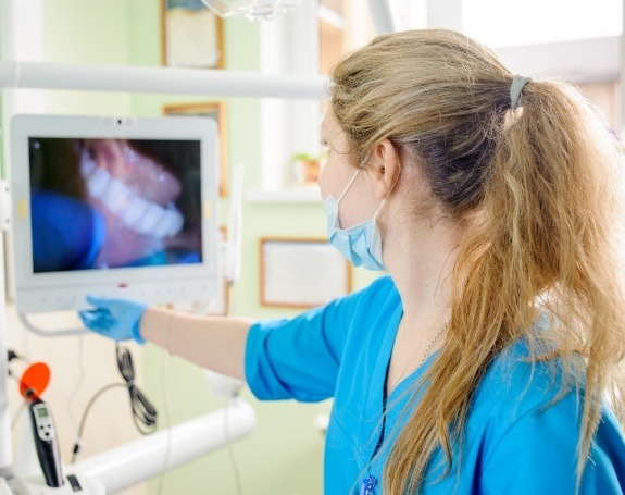 Dental team member looking at smile images taken with intraoral camera