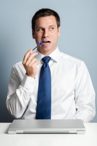 man chewing on a pen 