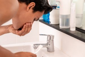 man rinsing with water