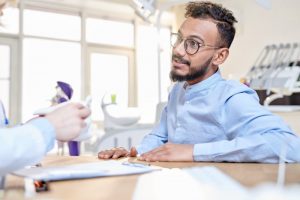 man speaking with dentist about deductibles 