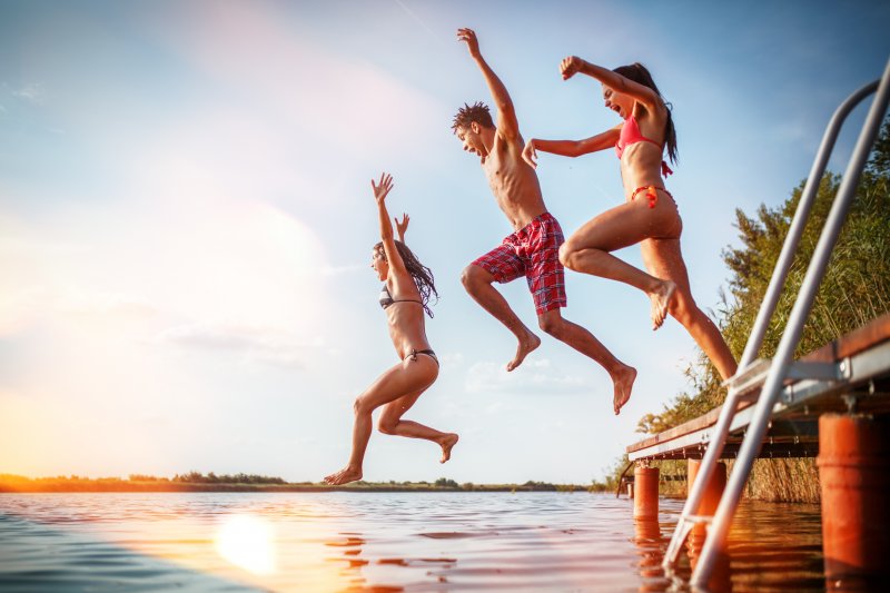 A group of people jumping into a lake